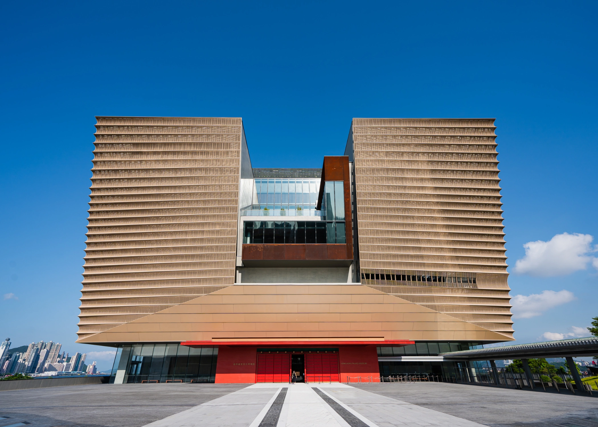 Exterior view of the Hong Kong Palace Museum in West Kowloon, featuring its bold, angular architecture inspired by traditional Chinese bronze vessels. The museum’s modern facade contrasts with its historical mission, housing over 900 priceless artifacts from Beijing’s Palace Museum, many displayed publicly for the first time.