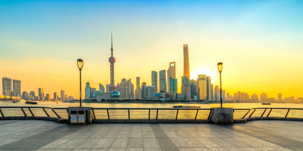 Busy city street in Shanghai surrounded by high-rise buildings and lights.