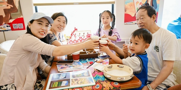 Family raising a toast in the spacious dining car of the Meet You Train luxury tourist express.