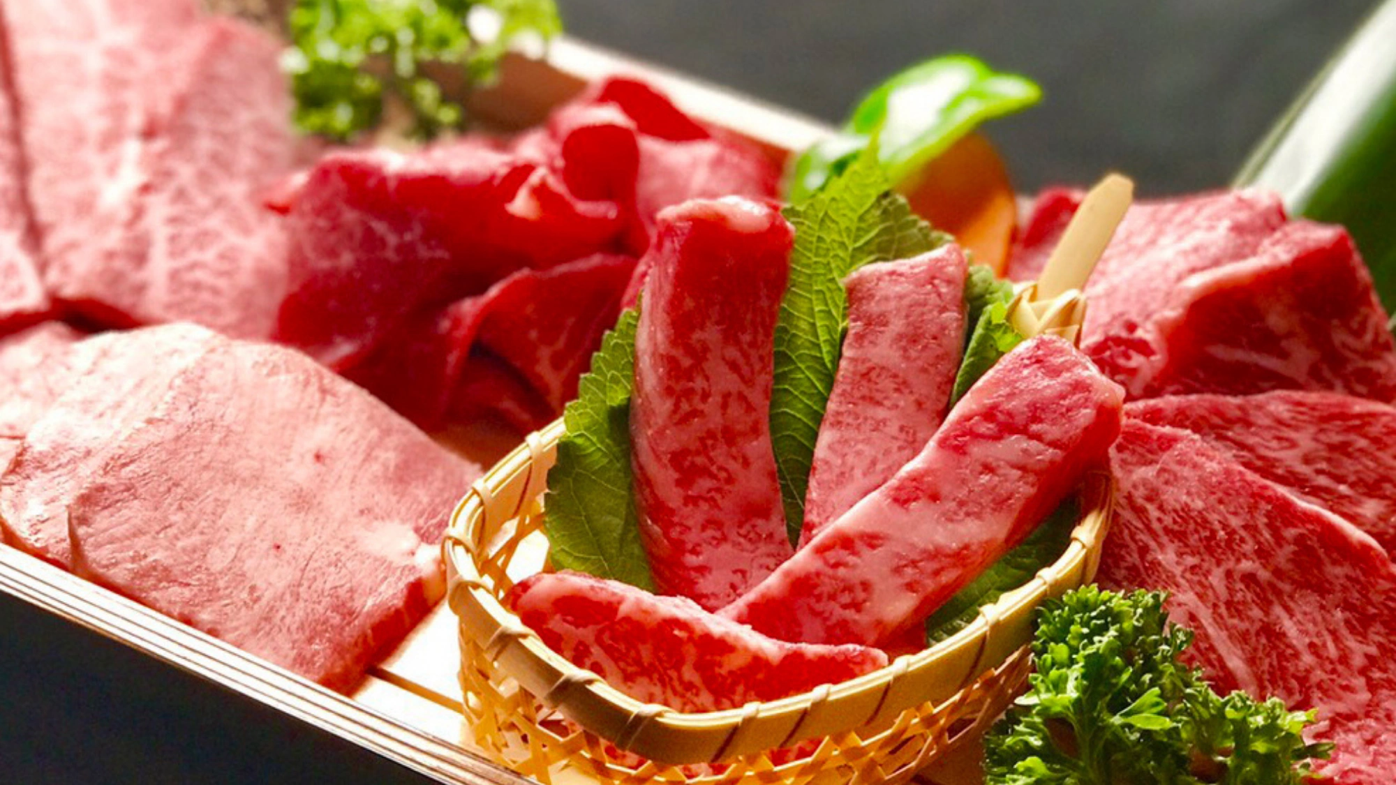 Premium cuts of marbled Halal Wagyu beef arranged on a wooden platter with green garnishes.