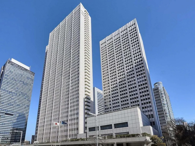 Keio Plaza Hotel and surrounding high-rise buildings under a clear blue sky.