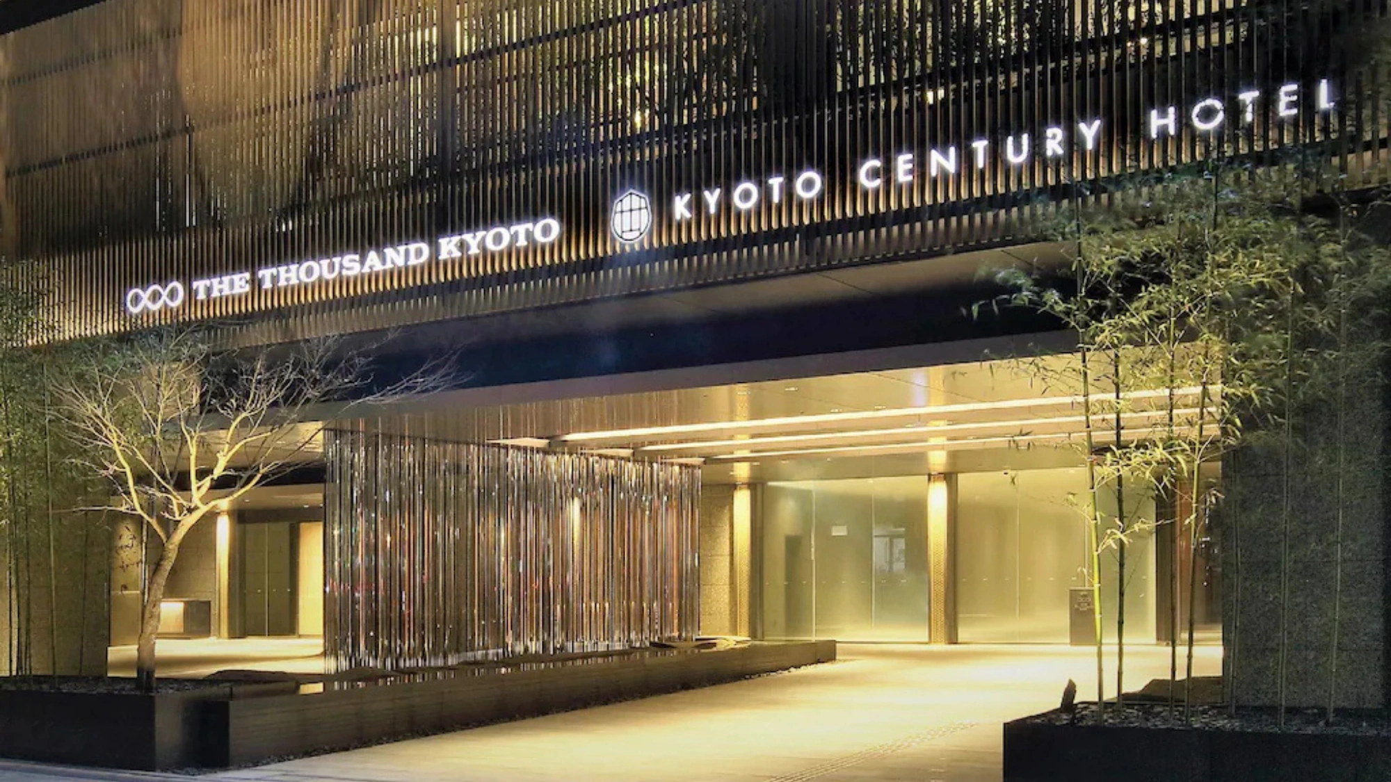 The sleek, modern entrance of Kyoto Century Hotel featuring vertical wooden slats and warm ambient lighting.