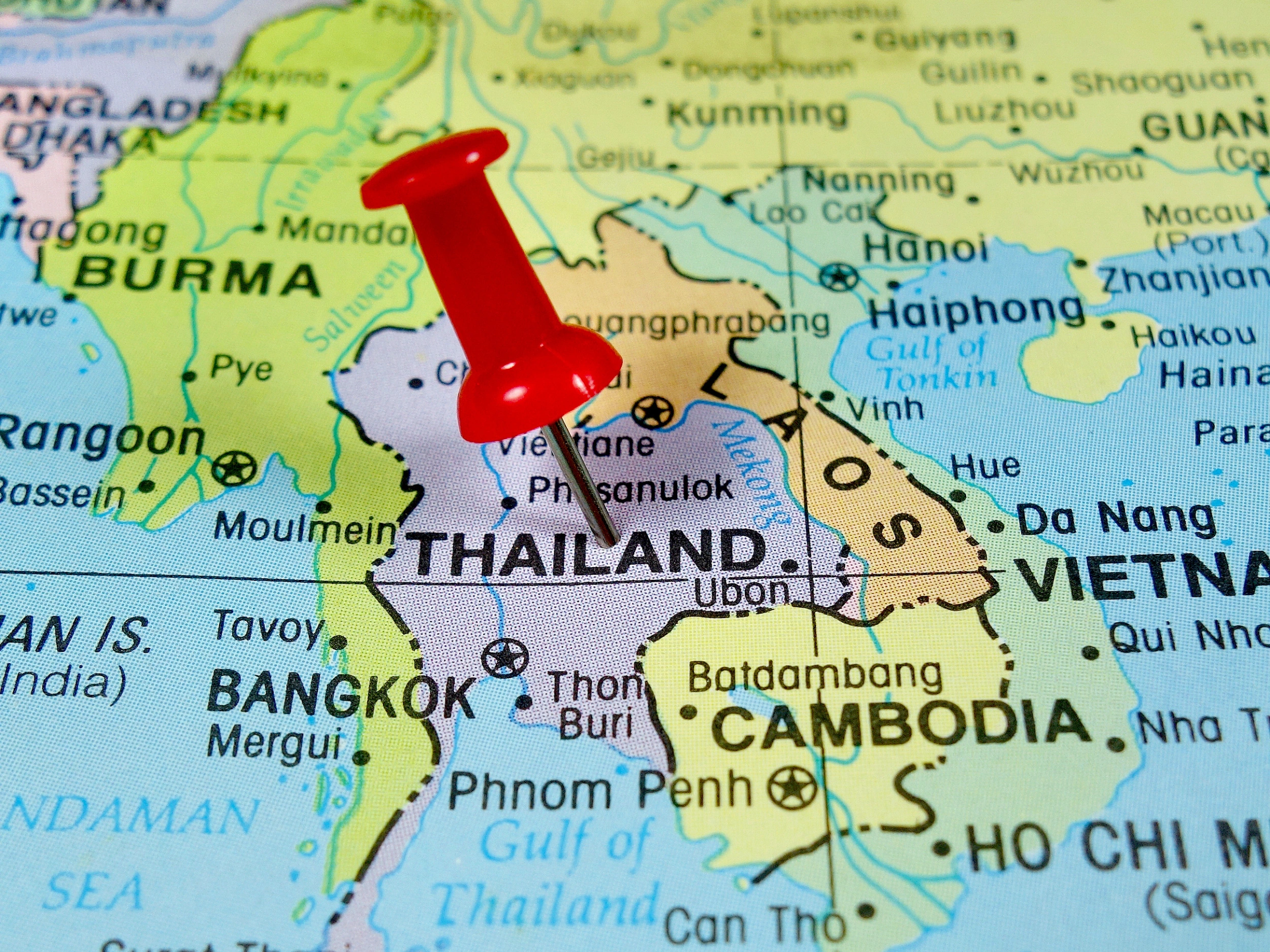 A map of Southeast Asia with a red pushpin marking the location of Thailand. The map includes parts of neighboring countries such as Burma (Myanmar), Laos, Vietnam, and Cambodia. Major cities like Bangkok in Thailand and Phnom Penh in Cambodia are also visible. The Gulf of Thailand and the South China Sea are labeled on the map.